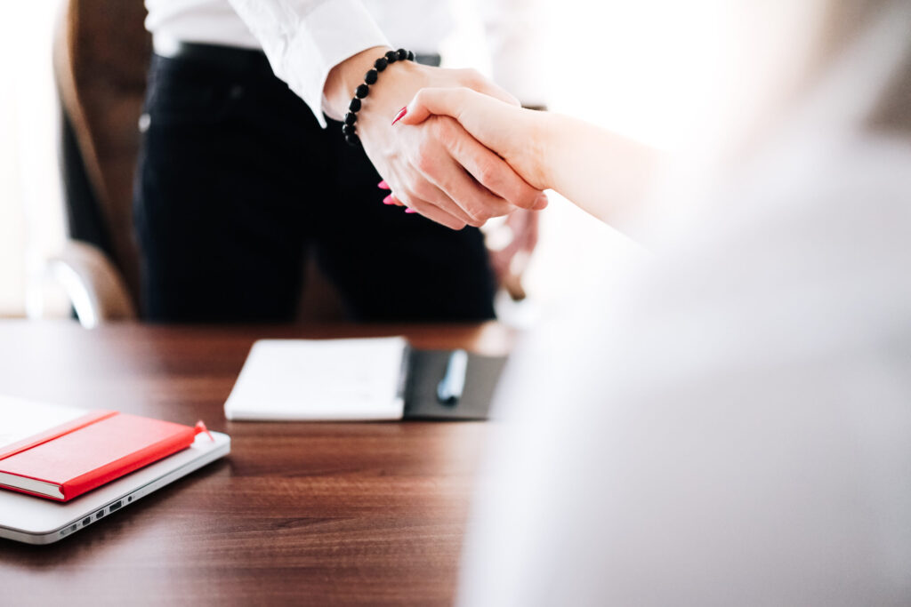 business man and woman handshake in work office picjumbo com scaled 1